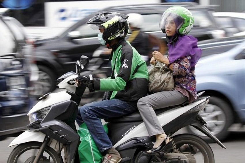 Tài xế xe ôm công nghệ của Go-Jek chở khách trên đường phố Jakarta, Indonesia. Ảnh: Reuters