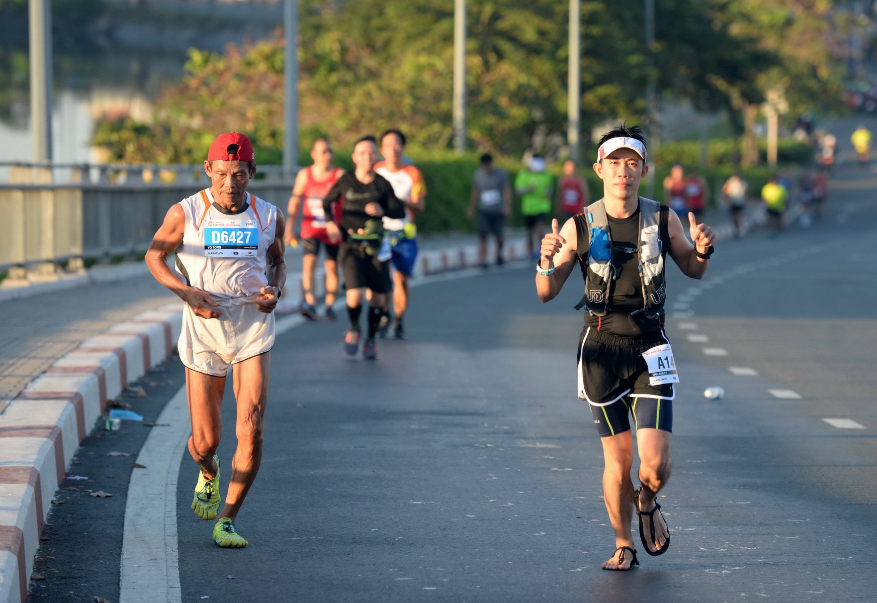 VĐV lớn tuổi Võ Tòng và vđv Thái OnlyC trên đường chạy marathon. | Ảnh: TTD