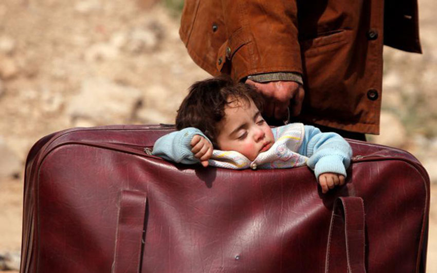 Một em bé ngủ trong túi ở làng Beit Sawa, đông Gouta, Syria ngày 15/3.