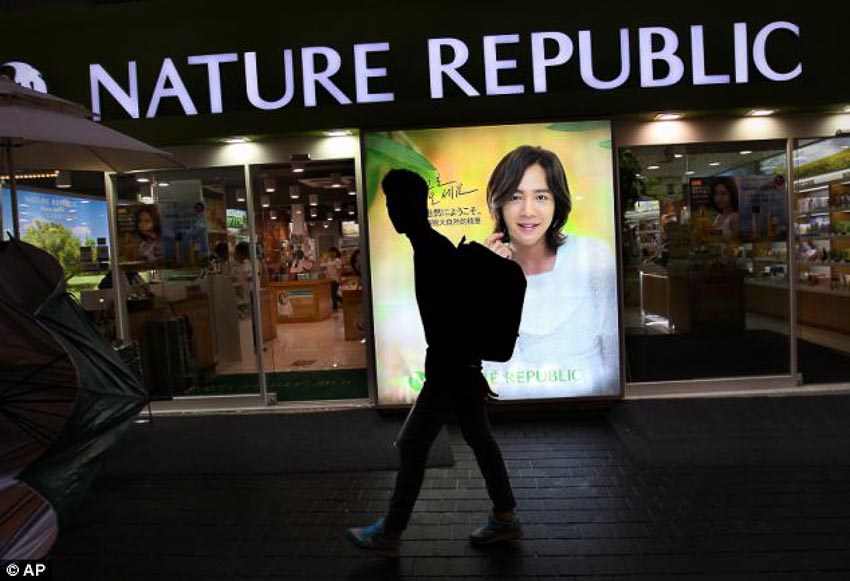 Một thanh niên đi ngang qua chuỗi cửa hiệu bán mỹ phẩm dành cho nam giới ở Seoul