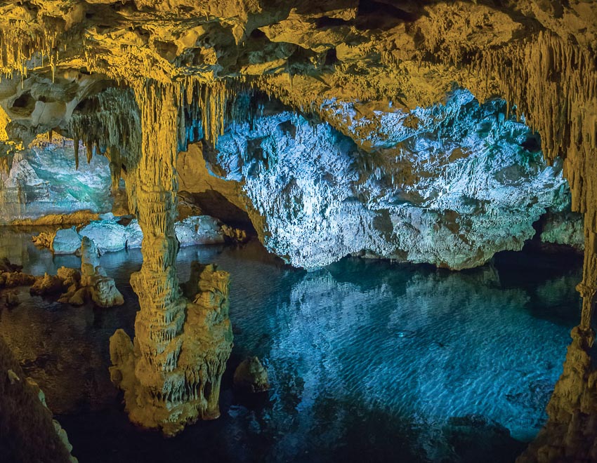 Hang động Grotta di Nettuno với mặt nước xanh biếc phản chiếu chùm thạch nhũ sắc cam