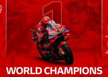 Francesco Bagnaia ăn mừng chức vô địch MotoGP 2025 cùng Ducati trên bục podium, sắc đỏ biểu tượng của đội đua Ý.