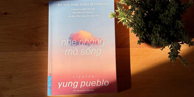 Bìa sách “Nhẹ nhàng mà sống” của Diego Perez (Yung Pueblo) đặt cạnh tách trà sáng trong ánh nắng nhẹ – biểu tượng của sự an yên và tự tại.
