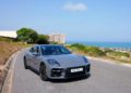 Porsche Panamera 4 E-Hybrid màu đen đang di chuyển trên đường phố đô thị hiện đại - 6