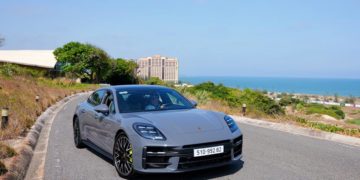 Porsche Panamera 4 E-Hybrid màu đen đang di chuyển trên đường phố đô thị hiện đại - 6
